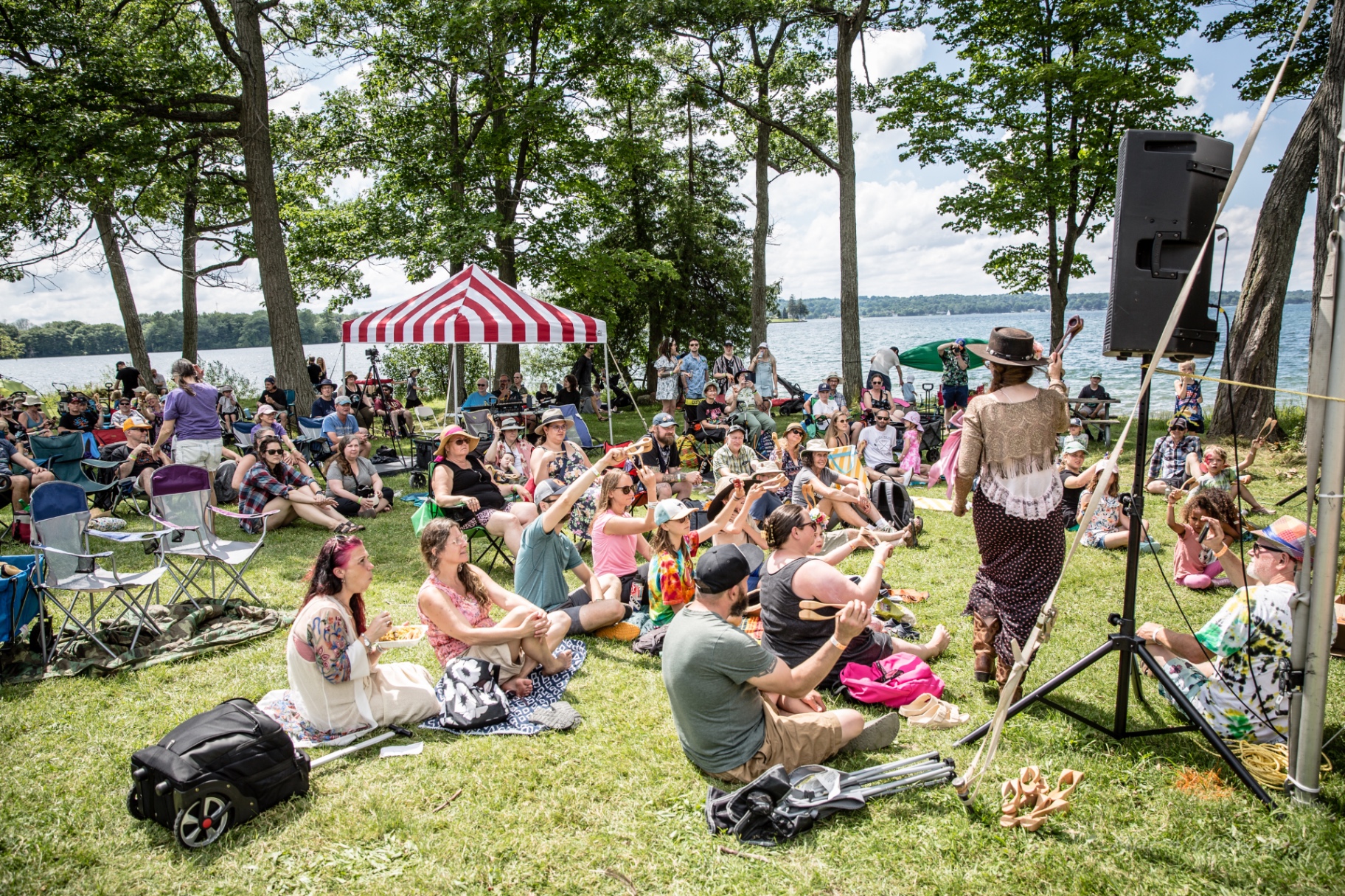 A spoon workshop by the lake with participants playing along