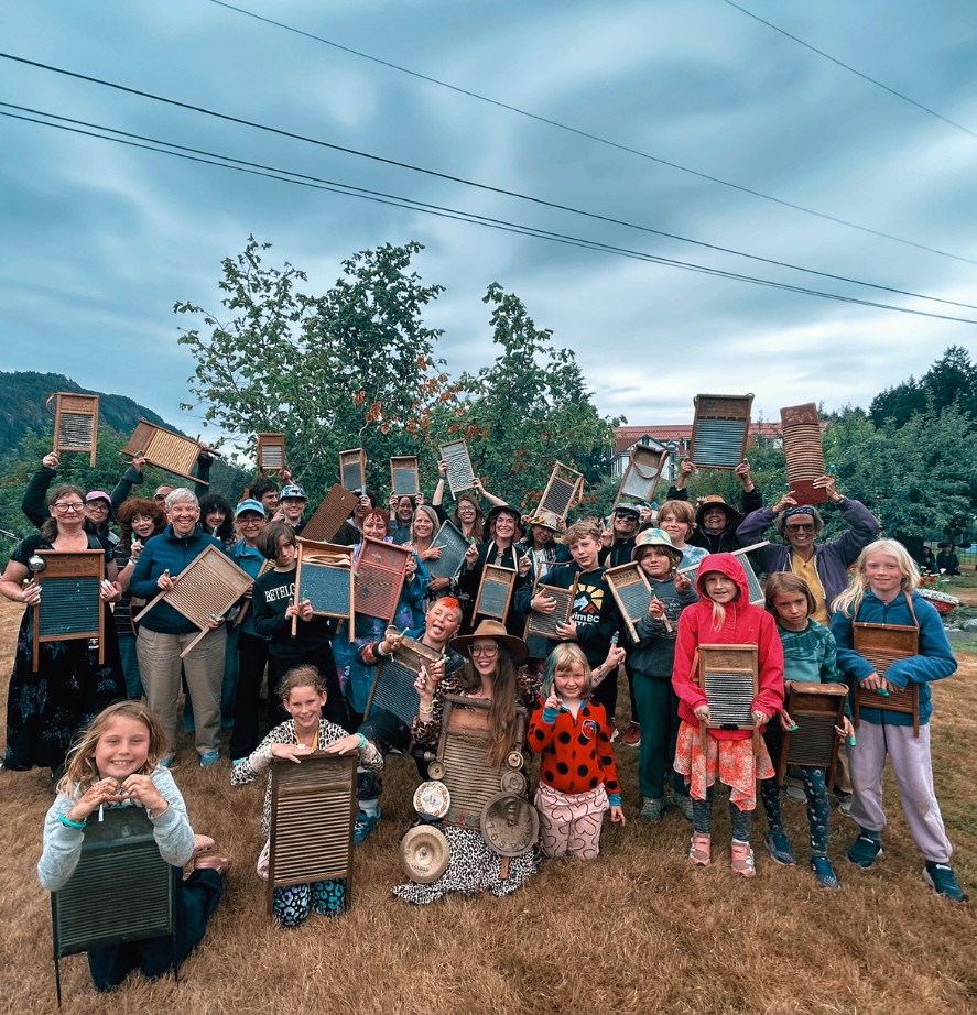 A washboard workshop group holding their washboards up in the orchard
