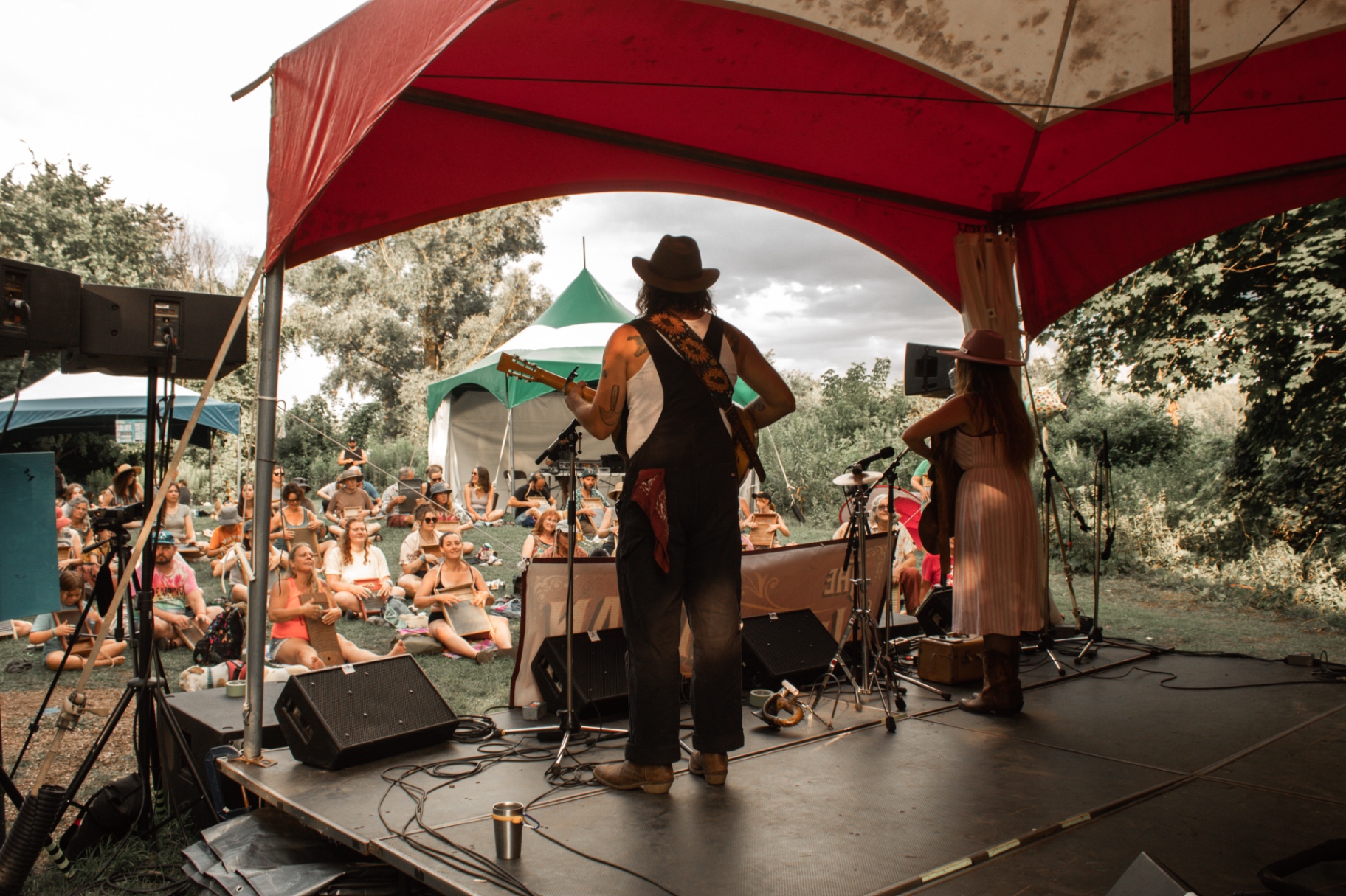 The Vaudevillian teaching a washboard workshop from the stage canopy