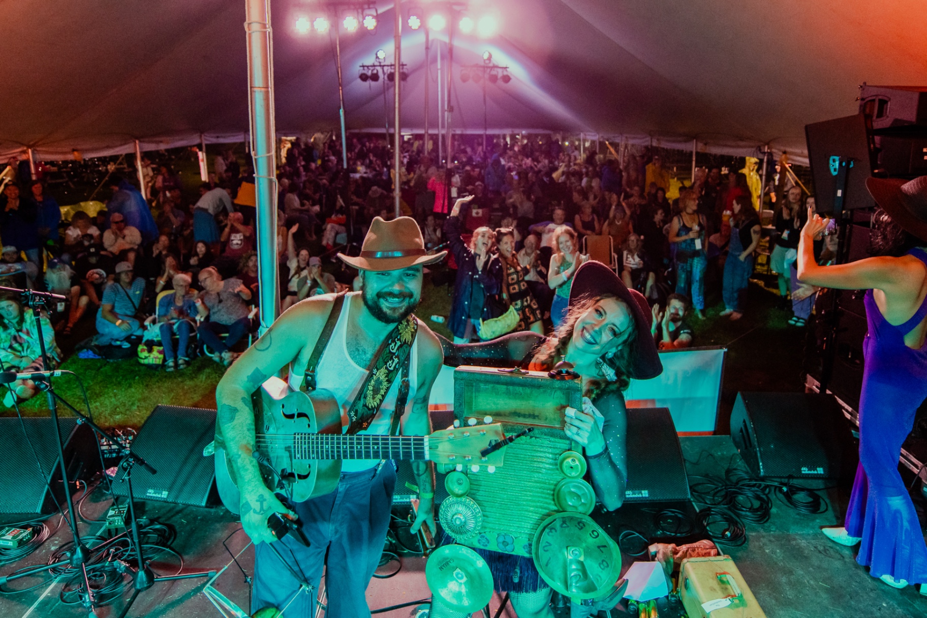 Jitterbug James and Norah Spades on stage with a large cheering festival crowd behind them